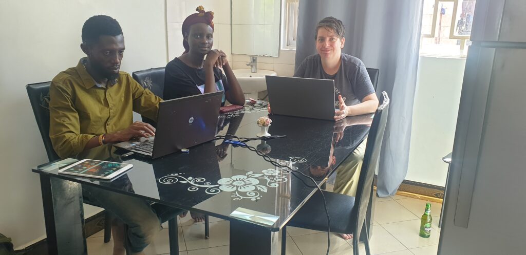 Three people working on laptops around a dining table.