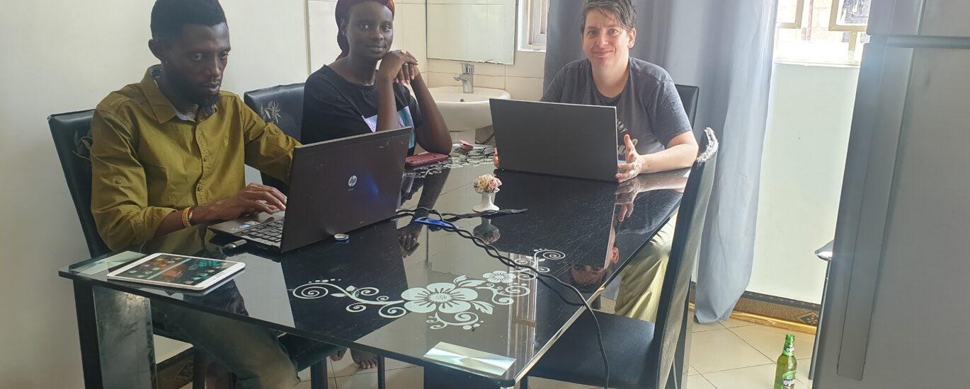 Three people working on laptops around a dining table.